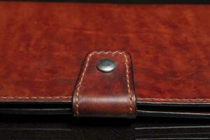 Part of a brown leather wallet or purse close-up. photo