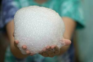 Laboratory chemistry experiment with foam and steaming.Laboratory chemical experiment with foam and steam. Hands holding foam. photo