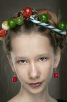 Portrait of a funny teenage girl with a wreath of sweets on her head. photo