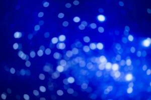 Blue blurred background with white bokeh spots. Festive background. photo