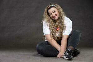 Beautiful fat woman on a gray background looks at the camera and smiles. The girl is a plus size model. photo