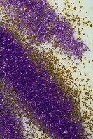 Purple and gold sparkles are scattered on a white background. photo