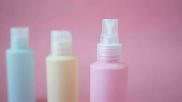 three bottle of cosmetic products on a pink background video