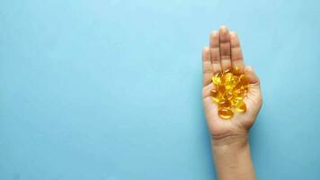 a person holding a handful of fish oil capsules video
