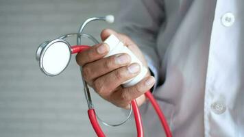 a person holding a stethoscope and pill bottle in their hand video