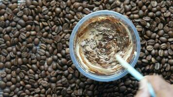 top view of cold coffee in a tall glass and coffee beans on table video