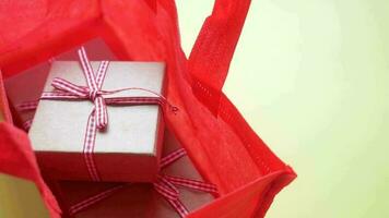 a red shopping bag with two wrapped gifts inside video
