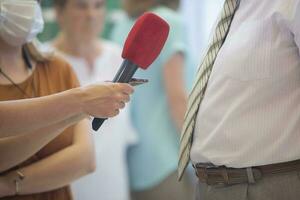 Interview. Hand with a microphone and an important gentleman in a tie. photo