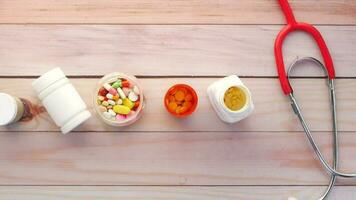 top view of medical pill containers and stethoscope on table video