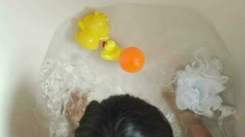 ein Kind spielen im das Badewanne mit ein Gummi Ente video