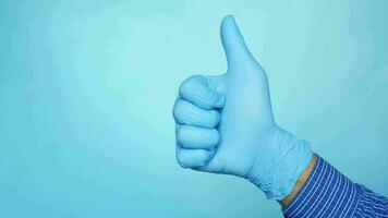 a person in blue latex gloves giving the thumbs up video