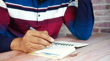 Businessman hand writing with pen on notepad video