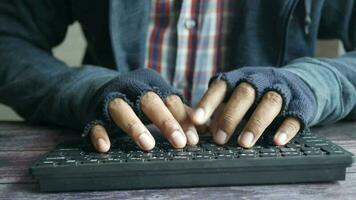 un hombre vistiendo guantes en su manos es mecanografía en un teclado video