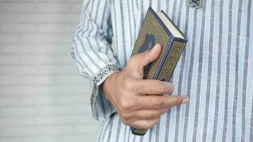 main d'homme musulman tenant le livre saint coran avec espace de copie video