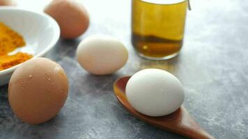 Eier, Kurkuma Pulver und ein Löffel auf ein Tabelle video