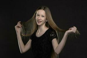 Beautiful teenager girl with long hair on a gray background. photo