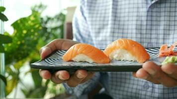 a man holding a plate with sushi on it video