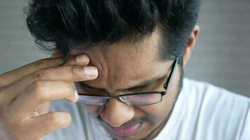 a man with glasses is holding his forehead video