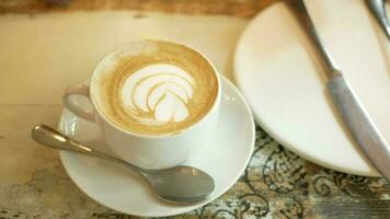 en kopp sent kaffe med blommönster på toppen på caféet video