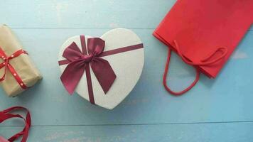 a heart shaped box with a red ribbon and a red bag video