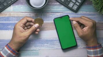 Vue de dessus de la main de l'homme à l'aide d'un téléphone intelligent sur le bureau video