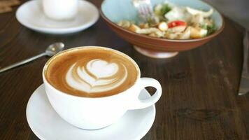 A cup of late coffee with flower shape design on top at cafe video