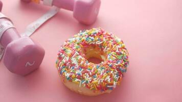 measuring tape wrapped around a dumbbell and donuts on table video
