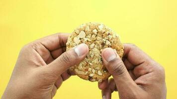 a person holding a cookie with nuts on it video