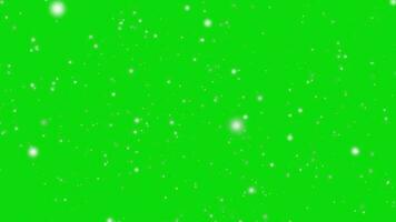 sfocatura bokeh astratto luccicante neve particelle caduta a partire dal superiore su il verde schermo video