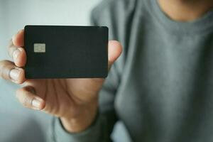 young men holding a black color credit card photo