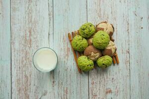 top view of sweet cookies and glass of milk on wooden table photo