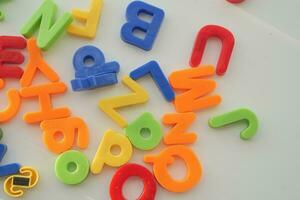 colorful plastic letters on white background, close up photo