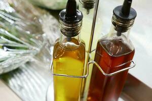 Bottles of aromatic olive oil on table photo