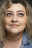 Portrait of a beautiful fat woman close-up on a gray background. photo