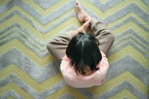 top view of sand a child sitting on carpet at home photo