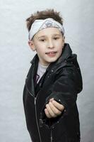 Portrait of a boy in a leather jacket and a bandage on his head. He smiles at the camera. photo