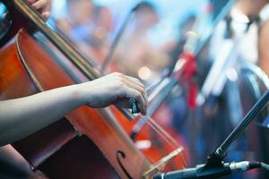 The musician's hand plays the cello. Musical symphony or jazz concert. photo
