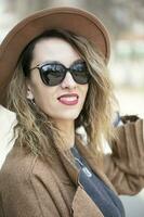 hermosa niña en un beige elegante sombrero y Gafas de sol al aire libre foto