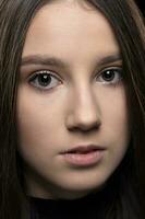 Close-up face of a beautiful young brunette girl. photo