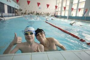 dos Niños en nadando tapas y gafas de protección en el Deportes piscina. foto