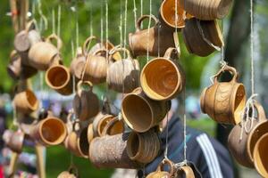 Clay souvenir cups are hung on ropes and sold at the fair. photo