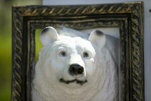 Plaster sculpture of a polar bear in a picture frame. photo