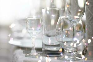 Various glass goblets with bright light from the lenses on the restaurant table. photo
