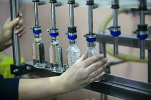 A row of glass bottles on a conveyor belt for the production of alcoholic beverages. photo