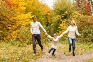 Picture of lovely family in autumn park, young parents with nice adorable daughter playing outdoors, have fun on backyard in fall, happy family enjoy autumnal nature photo