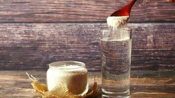 a person pouring a spoon of powder into a glass video