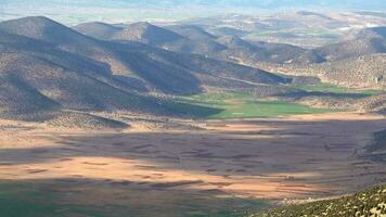 View From Mountain Peak to Small Plain Between Mountains video