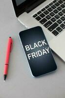 smartphone with black friday banner on the screen lies on wooden desk. Application on screen created in graphic program photo