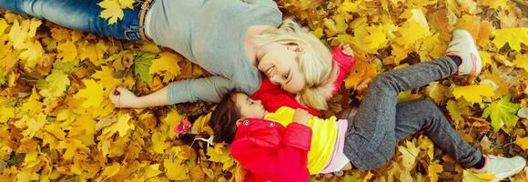 Mother and daughter in autumn yellow park. photo