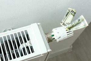 heating thermostat with money, dollar, expensive heating costs concept photo